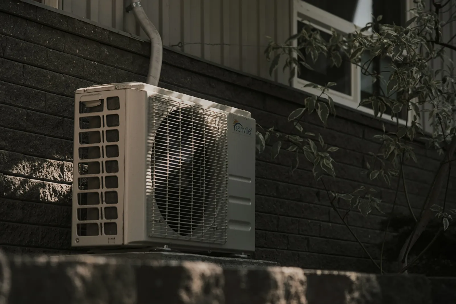 A ductless air conditioning unit mounted outside a brick house