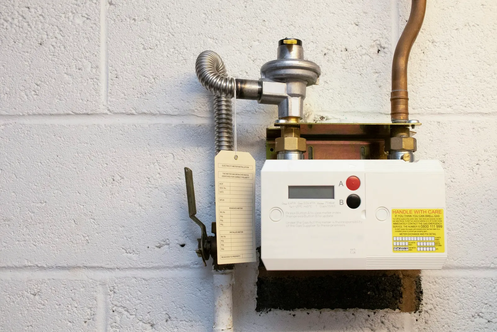 A wall-mounted gas water heater with its pipes